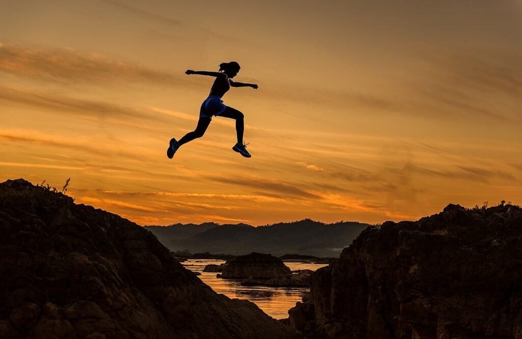 Woman jumping over a deep valley