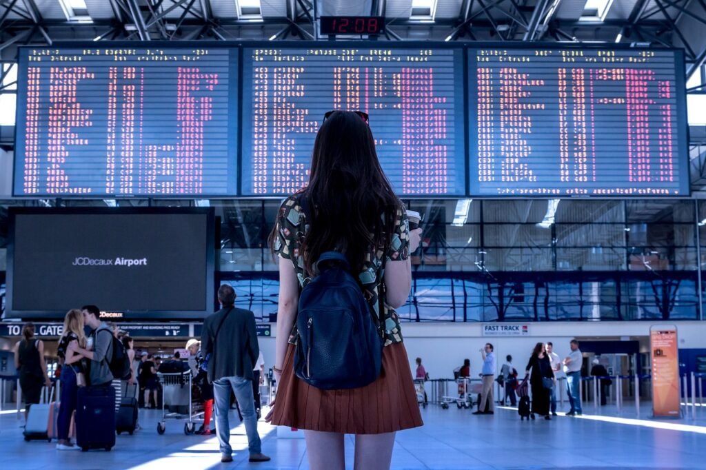 Girl standing at an airport looking at the flight departure board