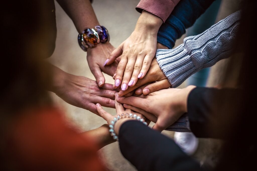 Closeup of nine hands stacked atop each other