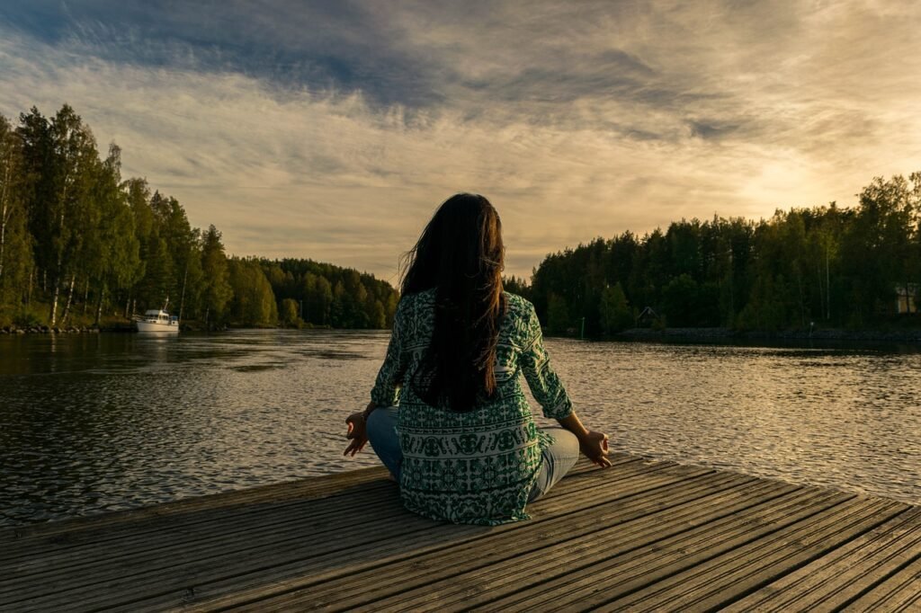 Woman meditating in front of a lake